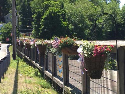 Wood bridge with flower pots on railing.
