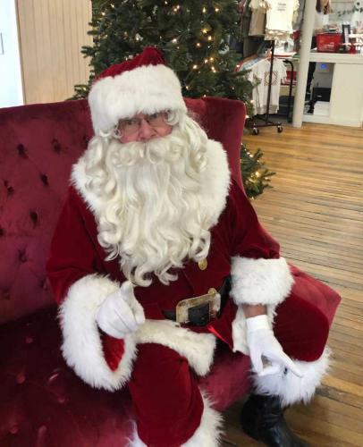 Santa sitting in chair waiting for little boys and girls.