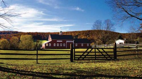 photo: stable sourrounded by fence and pastures