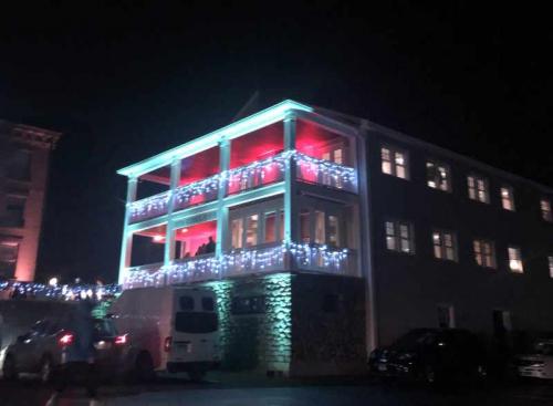 The Canton Historical Museum's 2-story building decorated with holiday lights at night.